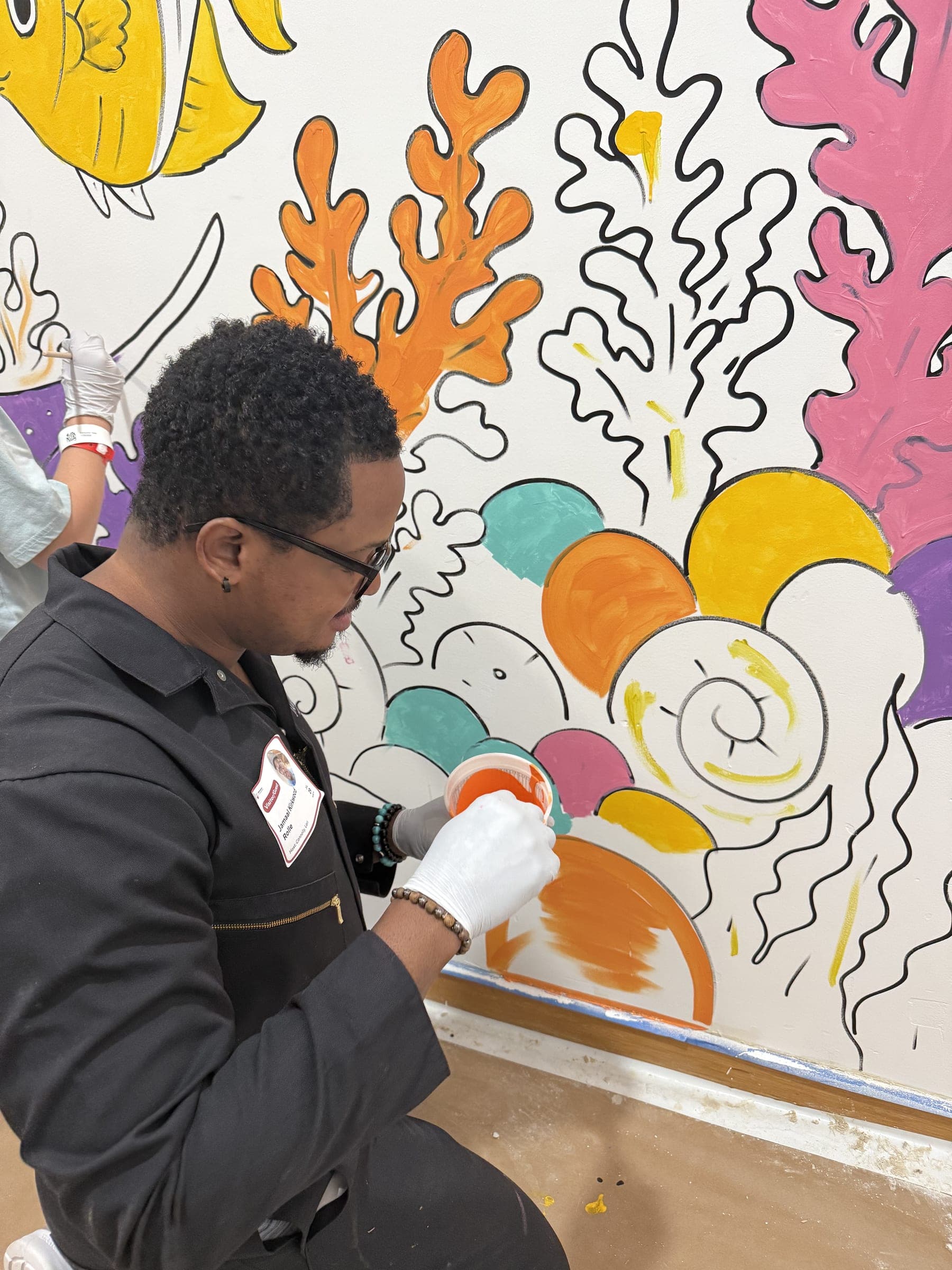 Jamaal Rolle drawing the mural in marker, directly onto the wall